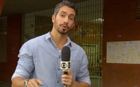 Danilo Vieira segura o microfone com a canopla da Globo com a mão direita