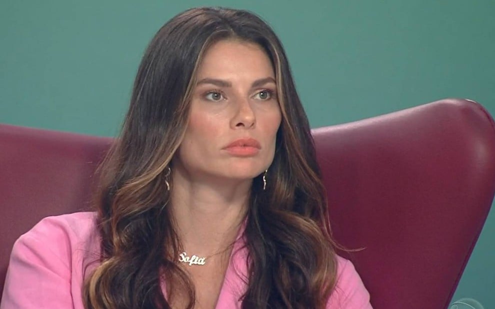 Dayane Mello olha para frente com cara de séria durante entrevista no Hora do Faro