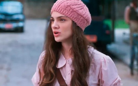 Debora Ozório usa uma touca rosa e está com expressão séria em cena como Olívia na novela Além da Ilusão