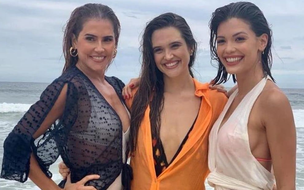 Deborah Secco, Juliana Paiva e Vitória Strada aparecem de roupa de banho e molhadas em cena na praia em Salve-se Quem Puder