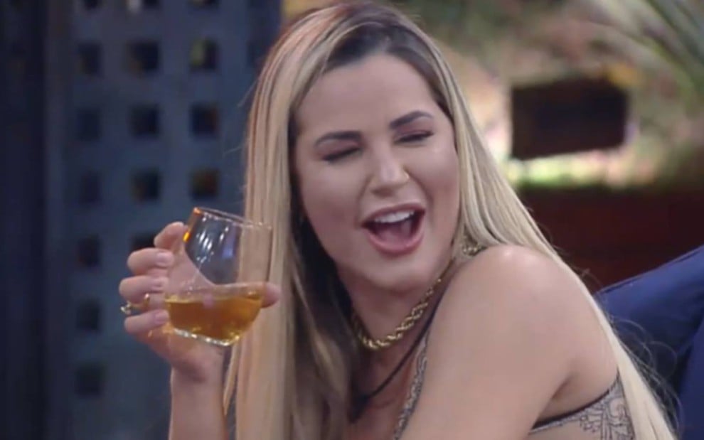 Foto de Deolane sorrindo e segurando um copo