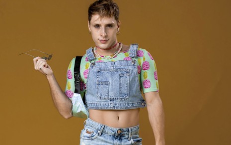 Diego Martins posa de cropped jeans, uma bolsa e uma blusa florida por baixo do colete