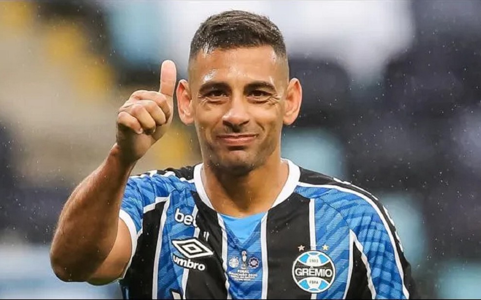 Diego Souza, atacante do Grêmio, usa camisa tricolor do clube e faz um sinal de joinha para a câmera