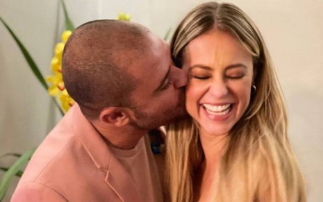 Diogo Nogueira beija Paolla Oliveira no rosto em clima de romance; a atriz ri com o gesto afetivo