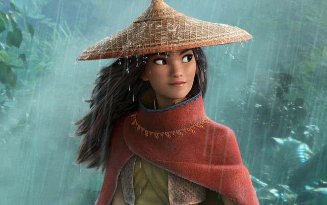Com um chapéu de palha, ao modelo asiático, um jovem de cabelos pretos, longos e de etnia chinesa leva um banho de chuva em cena de Raya e o Último Dragão