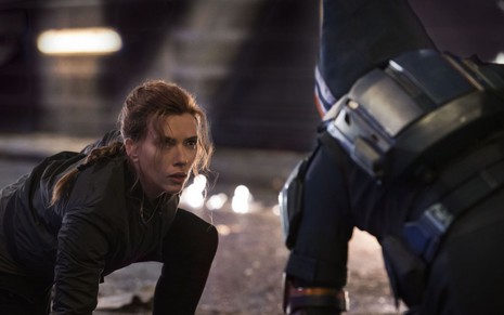 Scarlett Johansson está agachada e olhando séria para o Treinador