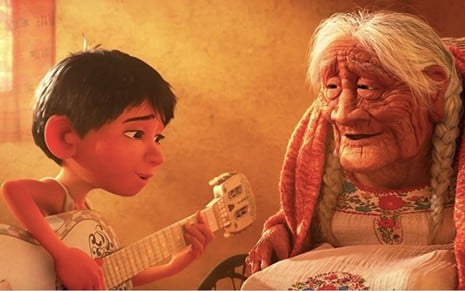 Cena do filme Viva - A Vida É uma Festa, da Disney, em que o personagem Miguel (Anthony Gonzalez) aparece cantando para avó Coco (Ana Ofelia Murguía)