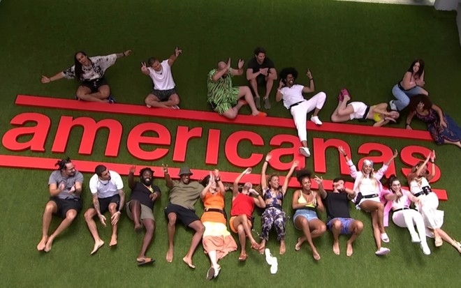 Elenco do BBB 22 está deitado sobre a logomarca das lojas Americanas, no BBB 22