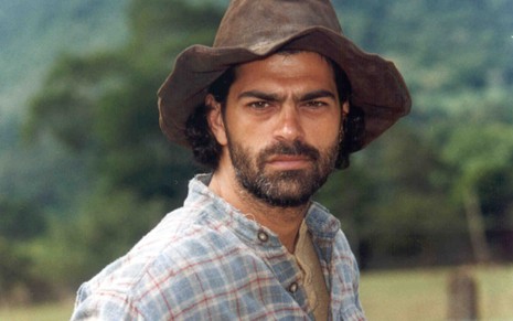 Eduardo Moscovis grava com barba, camisa xadrez e chapéu como Petruchio de O Cravo e a Rosa (2000)