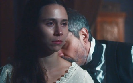 Atriz Daphne Bozaski faz cara de choro enquanto é beijada por Alexandre Nero em Nos Tempos do Imperador