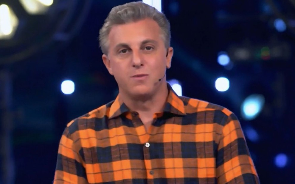 Luciano Huck com uma camisa xadrez em seu programa na Globo