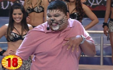 Tiago Salles em sua apresentação como Gato Louco no Se Vira nos 30 do Domingão do Faustão, em 2012, com maquiagem de gato e camisa polo rosa