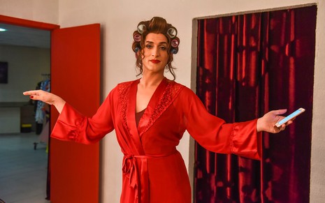 Paulo Gustavo como Dona Hermínia de vestido vermelho e braços abertos