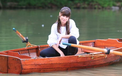Cena de Silvia (Alinne Moraes) em Duas Caras (2007), dentro de um barco no meio de um lago, com leve sorriso