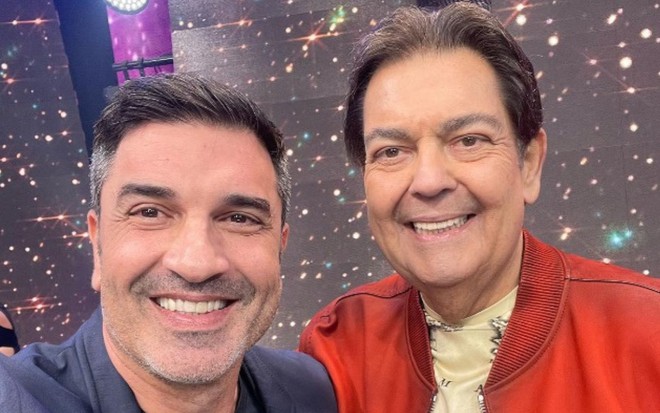 Edu Guedes posa ao lado de Faustão e sorri para a câmera