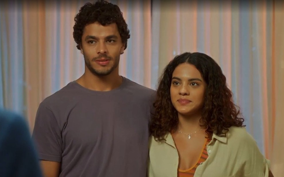 Em cena de Vai na Fé, Matheus Abreu está abraçado a Bella Campos, mas eles parecem constrangidos