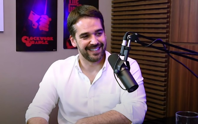 Eduardo Leite sorri enquanto conversa nos bastidores de podcast