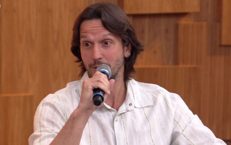 Vladimir Brichta em participação no Encontro com Fátima Bernardes desta segunda (22): ator está sentado, com camisa branca e microfone na mão direita