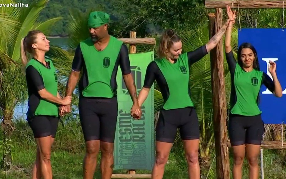 Antonela Avellaneda, Dinei e Laura Keller de mãos dadas, vestindo uma roupa preta e coletes verdes no Ilha Record