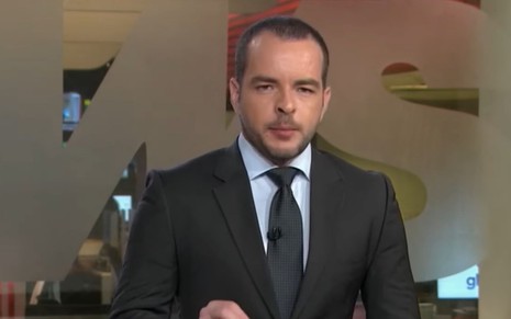 Erick Bang com um terno preto com uma gravata azul na Edição da 0h, da GloboNews
