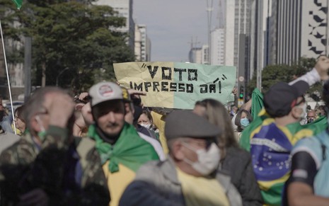 Manifestante na Avenida Paulista pede pelo voto impresso em um cartaz verde e amarelo