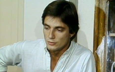 Fábio Jr. veste camisa branca e está com expressão séria em cena como Pedro na novela O Amor É Nosso