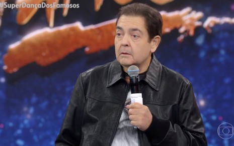 O apresentador Fausto Silva, de jaqueta preta, arregala os olhos durante o Domingão do Faustão de 6 de junho de 2021
