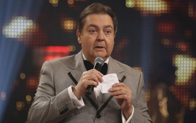 Fausto Silva com um terno de gala, com gravata preta e terno cinza, no prêmio Melhores do Ano 2019