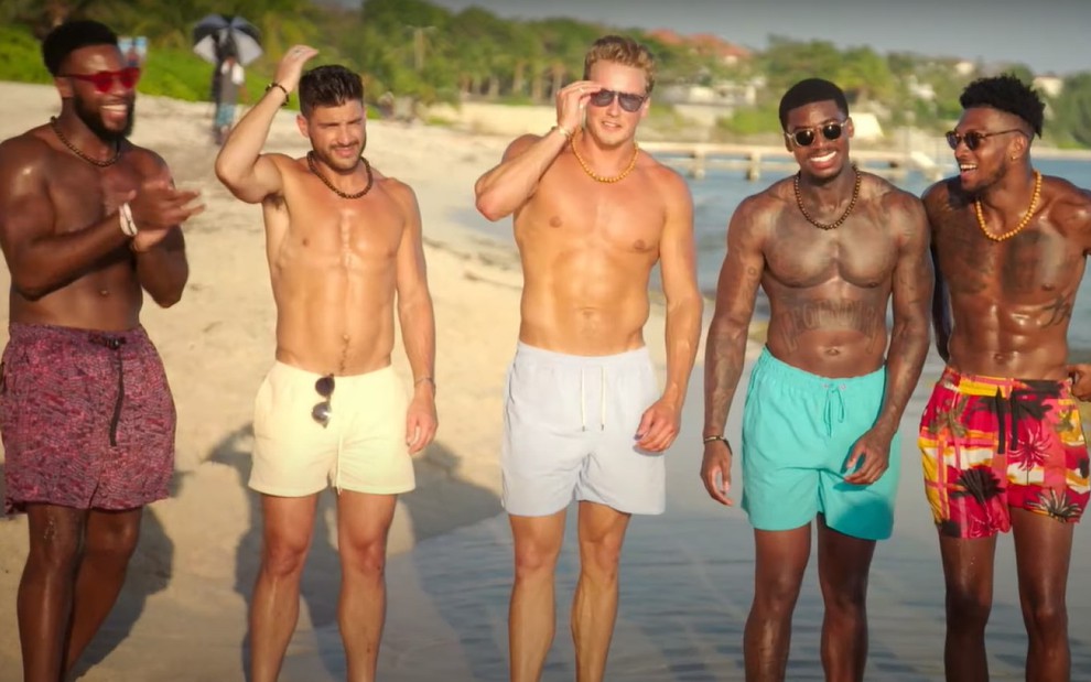 Cinco rapazes sem camisa em uma praia