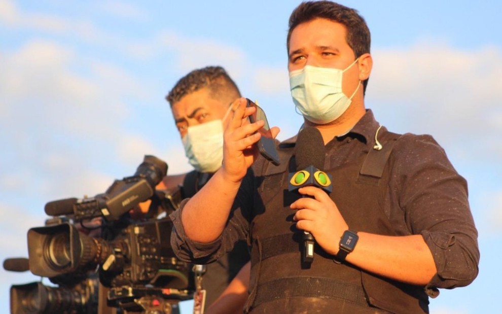Imagem de Felipe Garraffa segurando microfone ao lado do cinegrafista Marcelo Clayton na cobertura do caso Lázaro