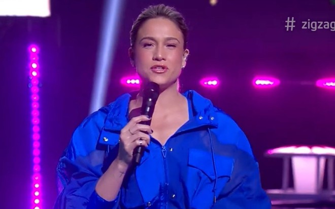 Fernanda Gentil no comando da estreia do Zig Zag Arena; ela está com uma roupa azul
