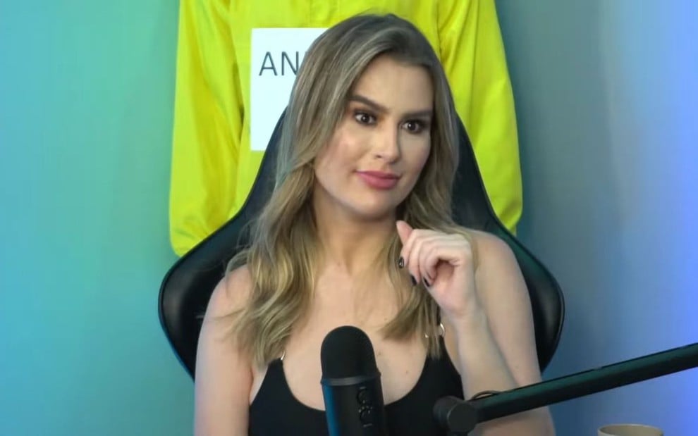 Fernanda Keulla em um estúdio de podcast com camiseta preta de alcinha