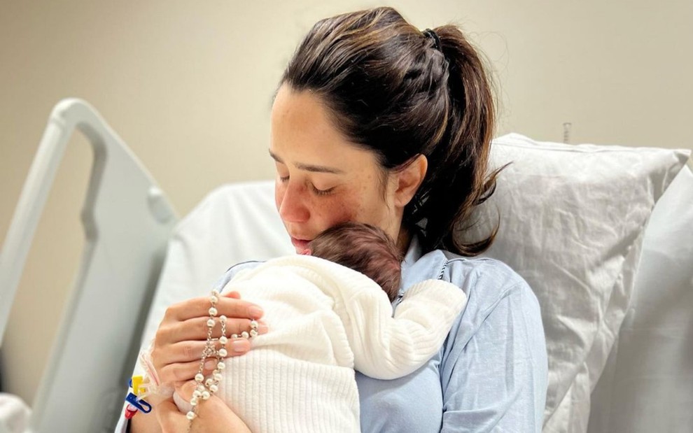 Fernanda Vasconcellos abraça filho recém-nascido, que aparece de costas
