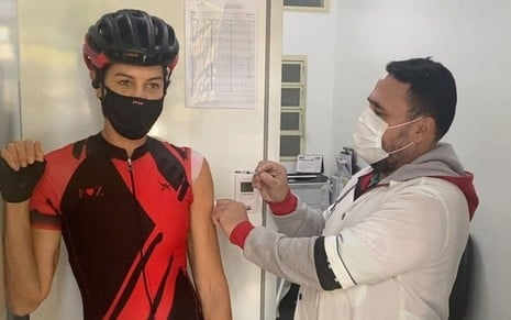 A ex-jogadora de vôlei Fernanda Venturini toma vacina contra a Covid-19 de capacete
