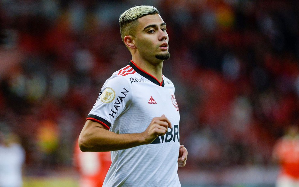Andreas Pereira, do Flamengo, corre em campo e veste uniforme branco com detalhes vermelho e preto