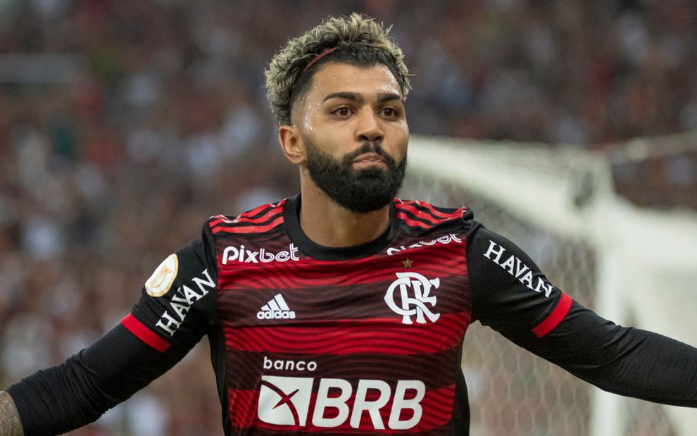 Gabigol, do Flamengo, comemora gol com braços abertos e veste uniforme listrado em preto e vermelho