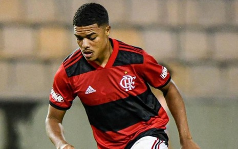 Jogador Igor Jesus, do Flamengo, veste uniforme vermelho com listras pretas durante partida da equipe