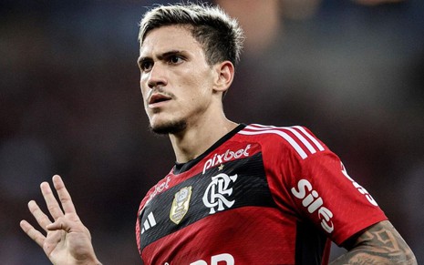 Foto do atacante Pedro com a camisa do Flamengo fazendo o número quatro com a mão direita