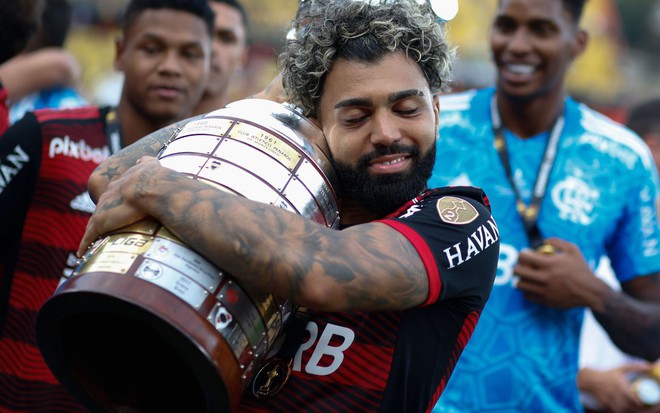 Gabigol, do Flamengo, abraça taça da Libertadores e veste uniforme listrado em vermelho e preto