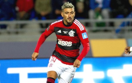 Arrascaeta correndo com a bola em jogo do Flamengo no Mundial; ele está com uniforme rubro-negro