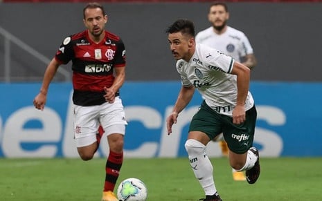 Everton Ribeiro, do Flamengo, vê Willian, do Palmeiras, dominar uma bola em um jogo entre Flamengo e Palmeiras
