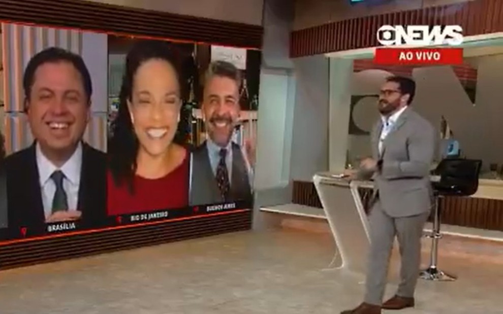 Flávia Oliveira de blusa vermelha, no telão da GloboNews