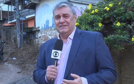 Flávio Fachel ao vivo no Bom Dia Rio na cobertura da tragédia de Petrópolis, ele está de terno azul, sem gravata e com um semblante de tristeza