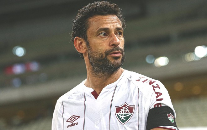 Fred olha de lado em jogo do Fluminense no Maracanã; o atacante está de uniforme branco e braçadeira de capitão