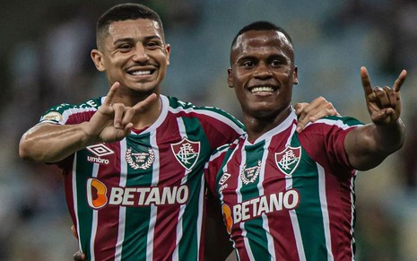 André e Arias, do Fluminense, comemoram gol e vestem uniforme listrado em grená, verde e branco