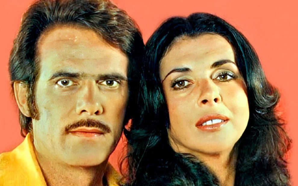 Francisco Cuoco com um bigode curto e uma camisa amarela, enquanto Betty Faria faz uma cara sedutora em uma foto tirada em 1975