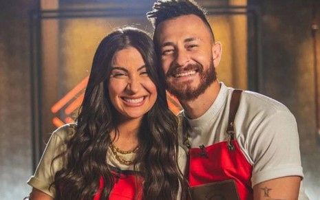 Bianca Andrade e Fred usando avental do Rolling Kitchen Brasil, abraçados e sorridentes