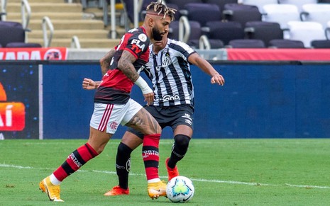 Imagem de Gabigol, do Flamengo, disputando bola contra jogador do Santos