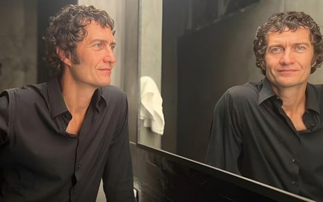 Gabriel Braga Nunes posa diante do espelho em um banheiro iluminado