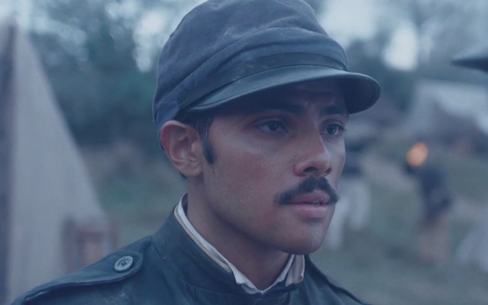 Gabriel Fuentes com roupas de soldado em cena como Bernardinho na novela Nos Tempos do Imperador
